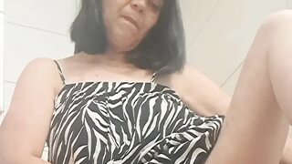 In the bathroom showing what's under her dress to her young lover on camera