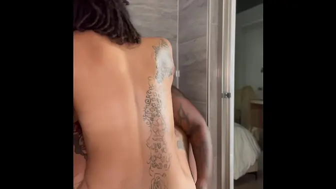 Close-up of ebony lesbian riding strap in shower