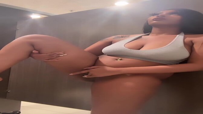 Horny ebony babe plays with toys in public toilet