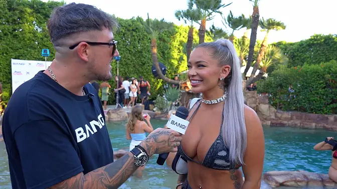 Inked bombshell shows off big boobs at pool party game show