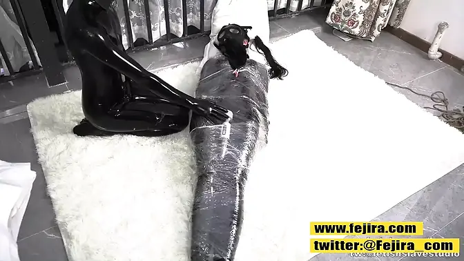 Lovely teen Asian girl bound and massaged in full body latex bondage