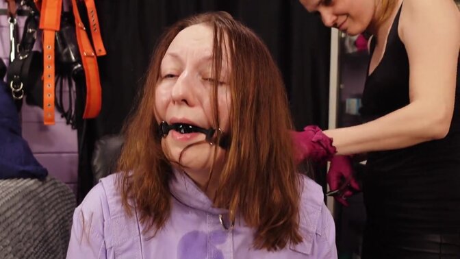 Mistress Priest cuts slave girl's hair while she cries in a straightjacket