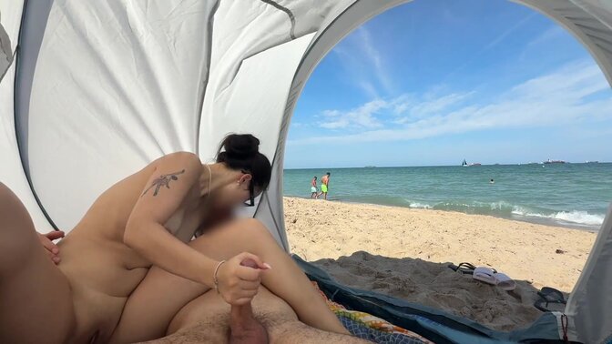 My Asian gf jerks me off while sitting in a public beach and I cum in her mouth
