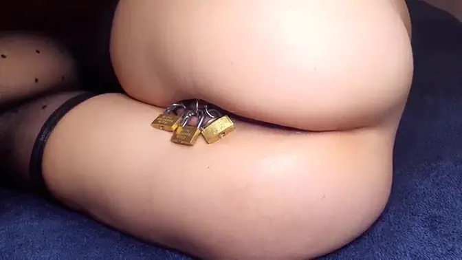 Pierced and caged, babe's ass gets fisted and squirted