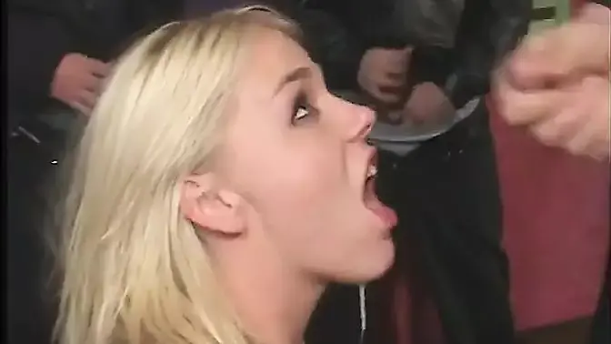 Sexy blonde with big natural tits gives a blowjob in a room full of tattooed men