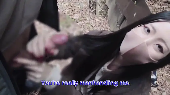 Slender Japanese girl gives handjob in forest