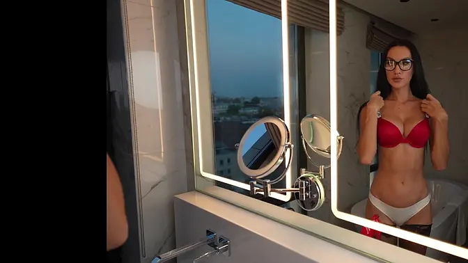 Tall, leggy brunette shows off long legs in stockings and lingerie