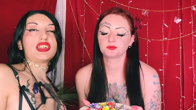 Two beauties French kiss while eating candy