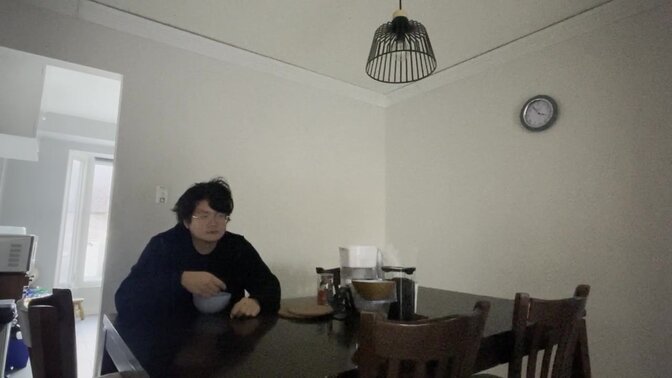 Unhappy Asian teenager cries while eating cereal alone in the dark,
